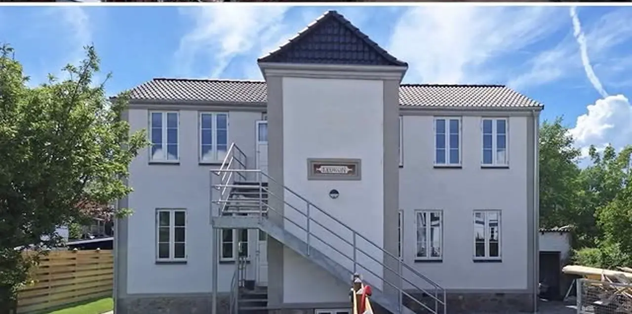 Efter — komplet renoveret facade med ny hvid puds, nye vinduer og nyt tag